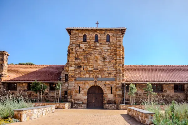 St Luke&rsquo;s College, the sandstone chapel tower under a clear blue sky