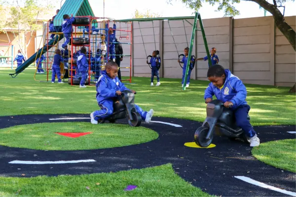 Children riding toy bikes on a painted track at The Tersia King Learning Academy